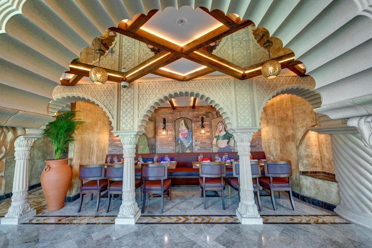 Dukes The Palm, A Royal Hideaway Hotel Dubai Esterno foto The photo showcases the interior design of a restaurant, characterized by a beautiful architectural style. There is an ornate archway supported by pillars, which adds a classical touch. The ceiling features a unique, layered design, creating an elega
