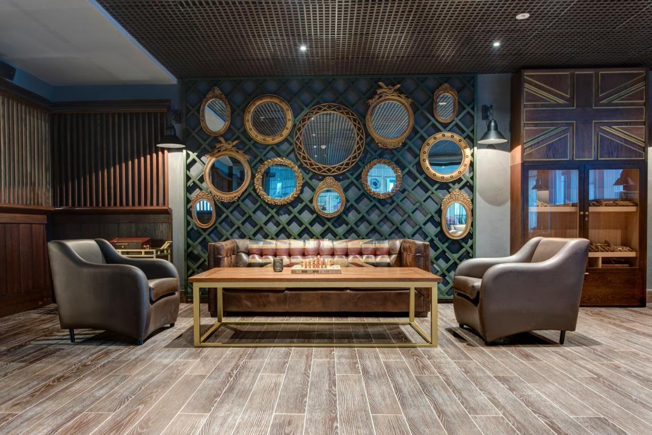 Dukes The Palm, A Royal Hideaway Hotel Dubai Esterno foto The photo features a stylish and inviting interior space. In the center, there's a brown leather sofa with a tufted design and a wooden coffee table in front of it. To either side of the sofa, there are two elegant armchairs, also in a muted color. 
