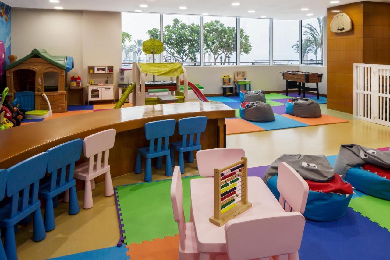 Dukes The Palm, A Royal Hideaway Hotel Dubai Esterno foto The photo shows a colorful indoor play area designed for children. The space features several elements, including:

- **Play Structures**: There is a small climbing structure with slides, along with a playhouse.
- **Furniture**: Brightly colored tabl