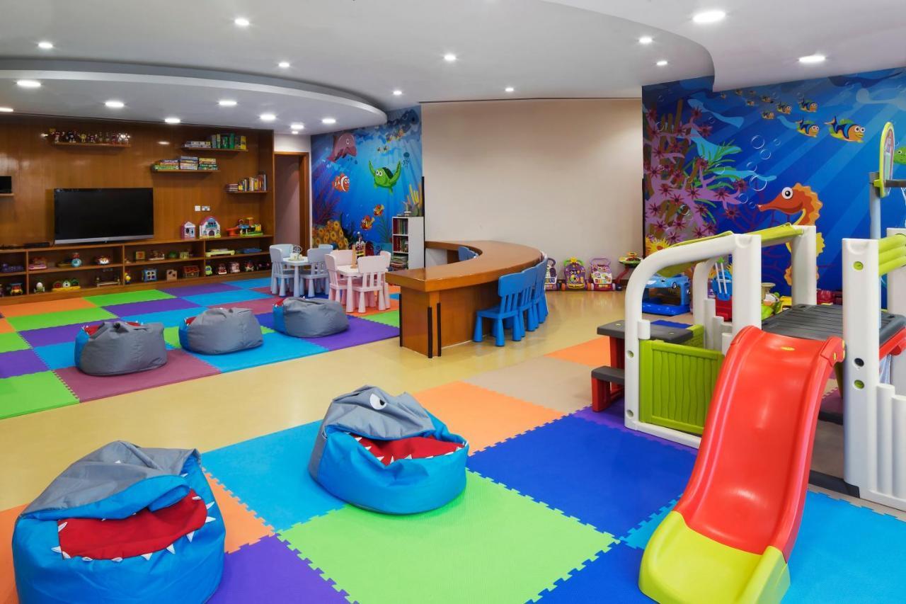 Dukes The Palm, A Royal Hideaway Hotel Dubai Esterno foto The photo shows a colorful children's playroom designed for fun and engagement. The flooring has various colored mats, creating a vibrant and safe environment for kids. 

In the center, there are several bean bags shaped like sharks, adding a playful