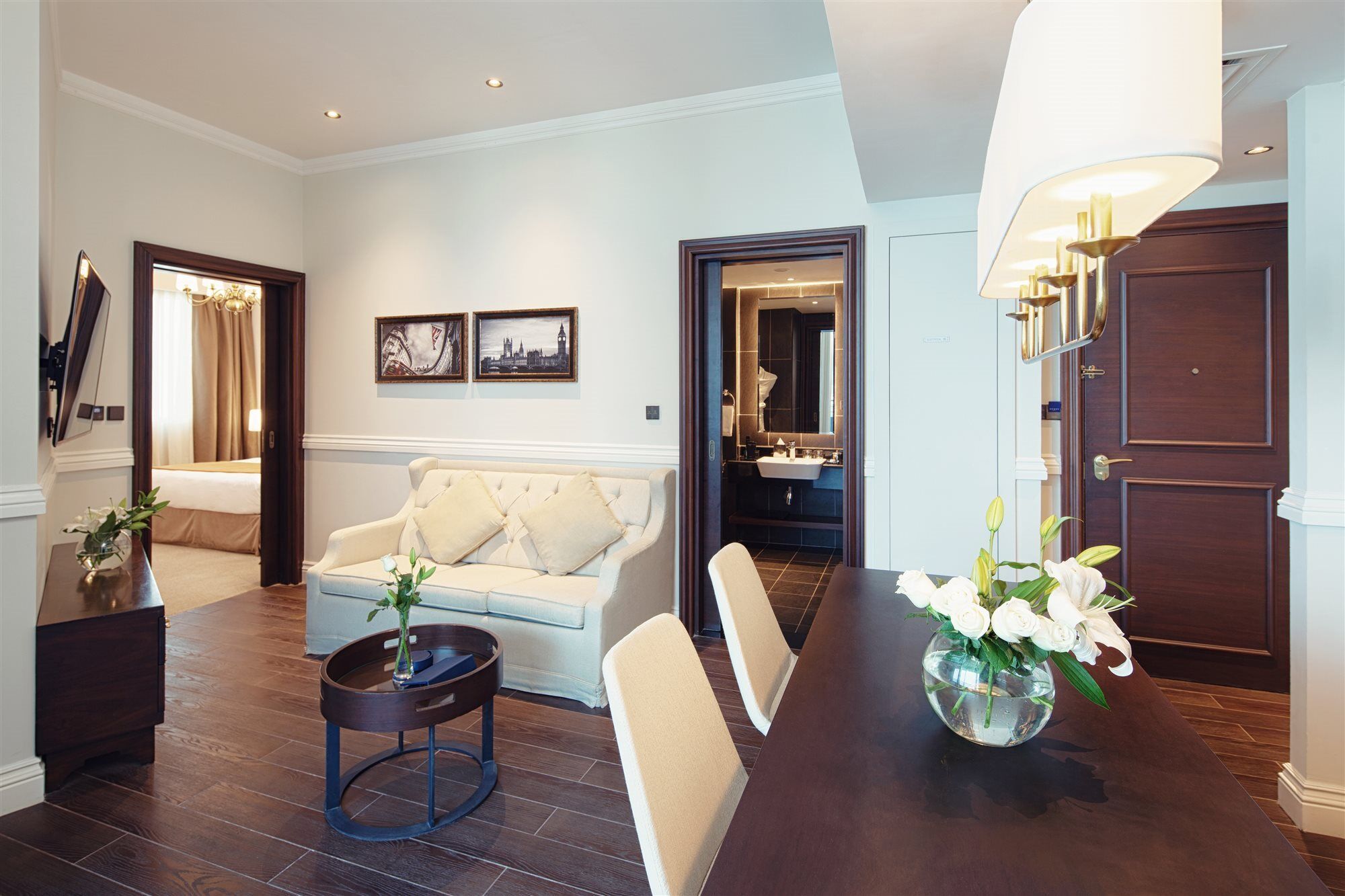 Dukes The Palm, A Royal Hideaway Hotel Dubai Esterno foto The photo shows a stylish hotel suite or living area. You can see a comfortable light-colored sofa with decorative cushions, positioned next to a small round coffee table. There are two framed artworks on the wall, adding a touch of decor. Directly a